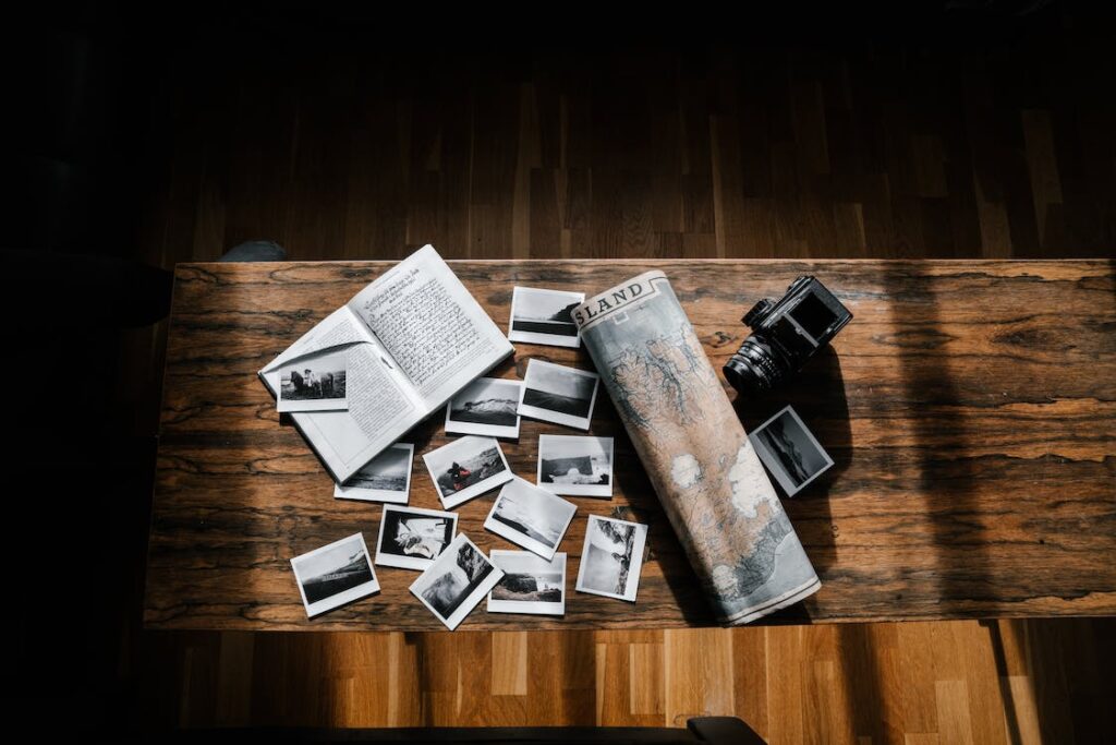 A photo of a camera on a wooden table with a map, symbolizing the beginning of the journey into boudoir photography